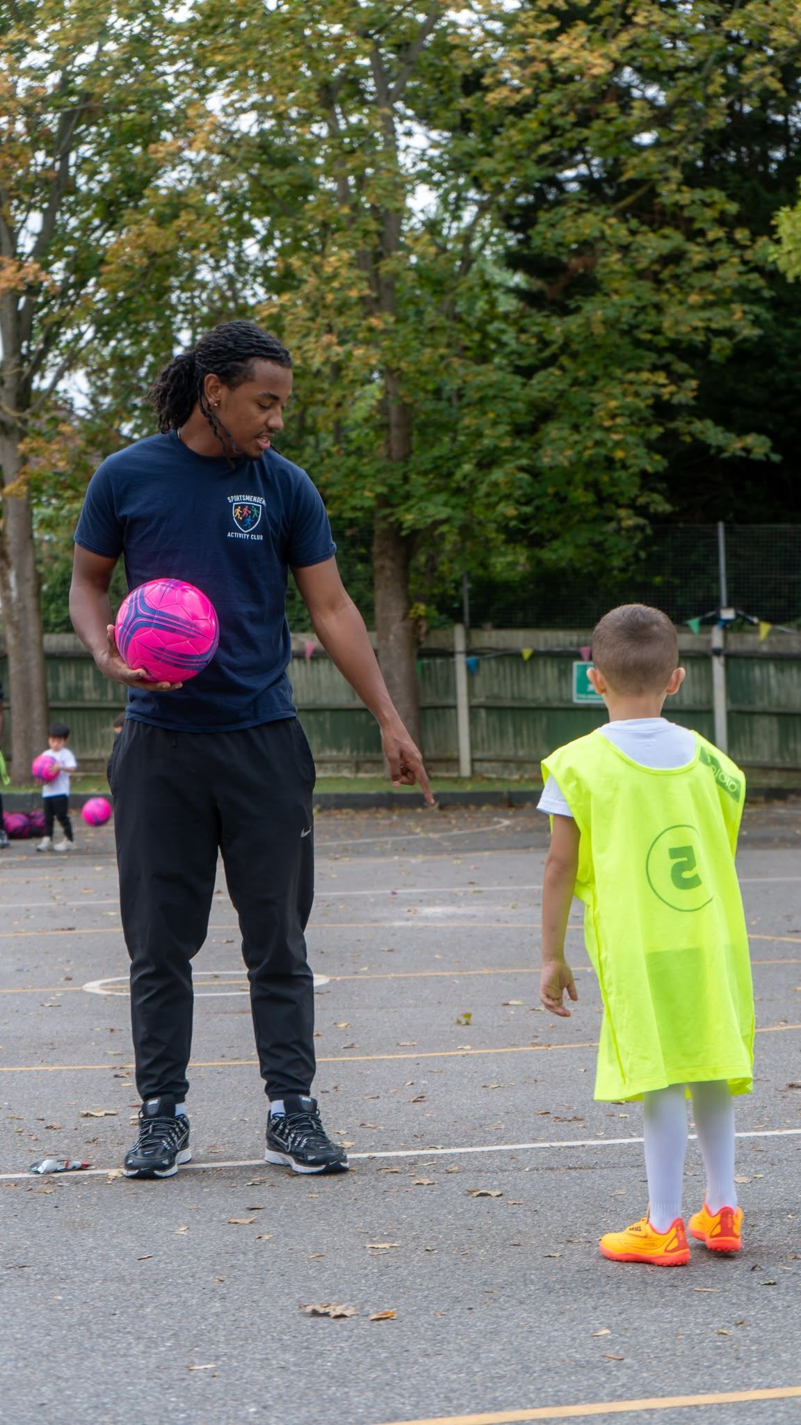 Coach running a football drill in the playground