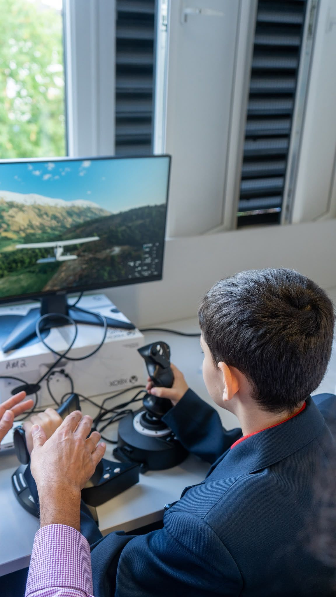 Pupil flying with joystick controls on a simulator